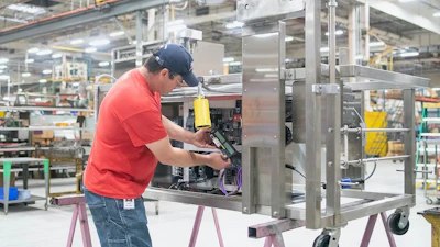 John Priddy, gerente de fabricación de Krispy Kreme, instala el kit G120 en la sección de freidora de una máquina de donas.