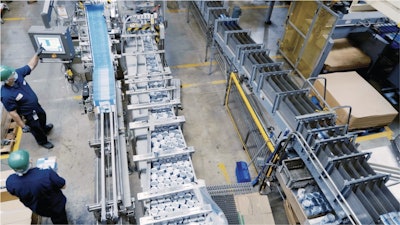 Entrada de producto etiquetado enlatado y aplicado con pegamento de 5 oz y 7 oz en la estuchadora en las instalaciones de Bumble Bee en Santa Fe, California. Tenga en cuenta el diseño de tres carriles paralelos, con el producto entrando primero en el espacio y alimentando la estuchadora en la pista central. Después de que el producto es encartonado y encarrilado, gira bruscamente 180 grados, transportando el producto corriente abajo mientras está paralelo a la encartonadora. Luego, el producto da otro giro más ancho de 180 grados alrededor de la estuchadora y finalmente viaja paralelo a las dos pistas anteriores nuevamente para el empaque en bandeja.