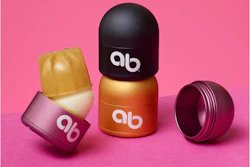 Un sistema de empaque de humectante labial recargable/reutilizable de arriba y más allá incluye una caja metálica en forma de cúpula y repuestos de productos empacados en material de base biológica.