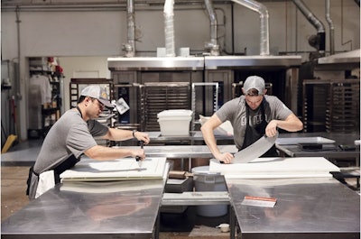Trabajadores cortan prototipos de barra de snacks reciclados ReGrained para un socio de marca.