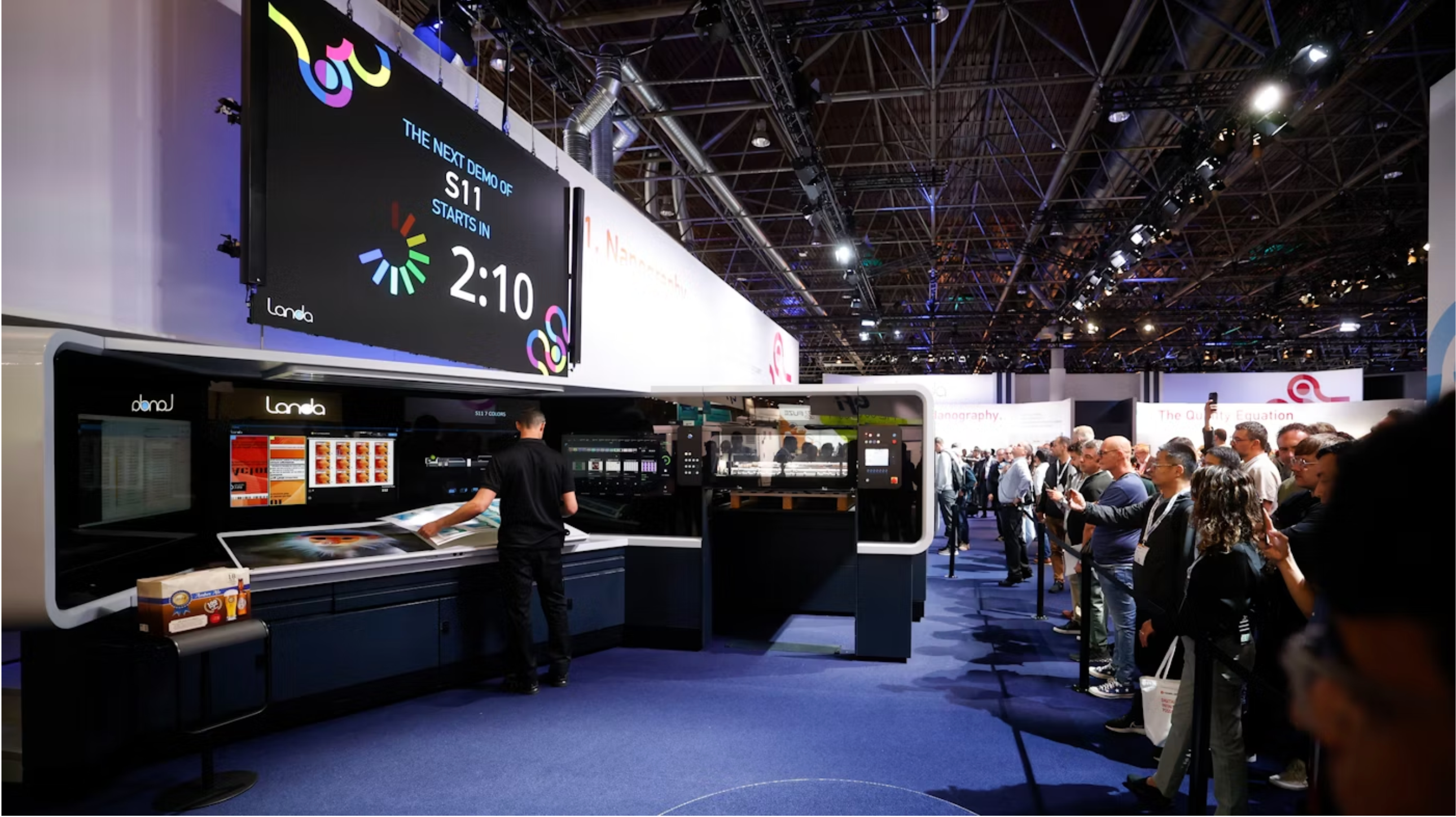 Un operador prepara una demostraci&oacute;n de cart&oacute;n en una impresora digital nanogr&aacute;fica Landa S11 en drupa 2024.