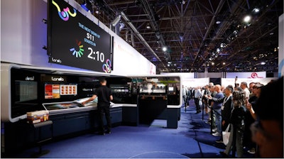 Un operador prepara una demostración de cartón en una impresora digital nanográfica Landa S11 en drupa 2024.