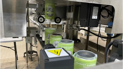 Las fundas termoencogibles se 'disparan' sobre las latas brillantes que esperan, en la imagen, mientras se desplazan hacia el túnel de vapor.