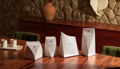 El empaque combina estética y funcionalidad con un diseño minimalista en blanco puro que resalta sus formas escultóricas. Además, refuerza el compromiso ambiental de la marca al ser reciclable y elaborado con tintas orgánicas libres de solventes.