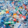 Massive pile of discarded plastic water bottles in various colors and brands