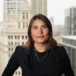 Professional woman in black attire standing with city skyline background