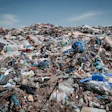 Massive pile of mixed plastic waste and debris under blue sky