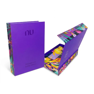 Purple Nubank branded book-style packaging with colorful geometric patterns and matching decorative box insert