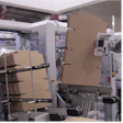Industrial packaging equipment with cardboard boxes in a manufacturing facility