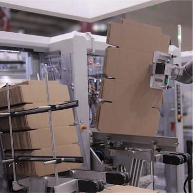 Industrial packaging equipment with cardboard boxes in a manufacturing facility