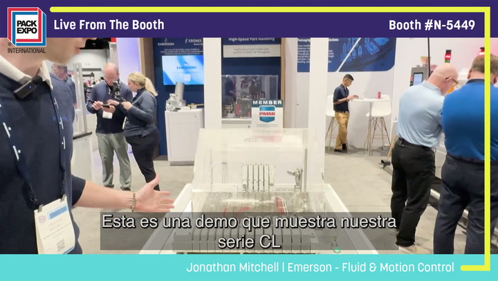 Live demonstration at Pack Expo booth N-5449 showing industrial equipment with visitors and staff engaged in discussion