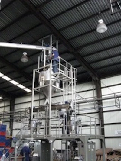 Industrial tower structure with metal scaffolding and equipment inside a warehouse facility