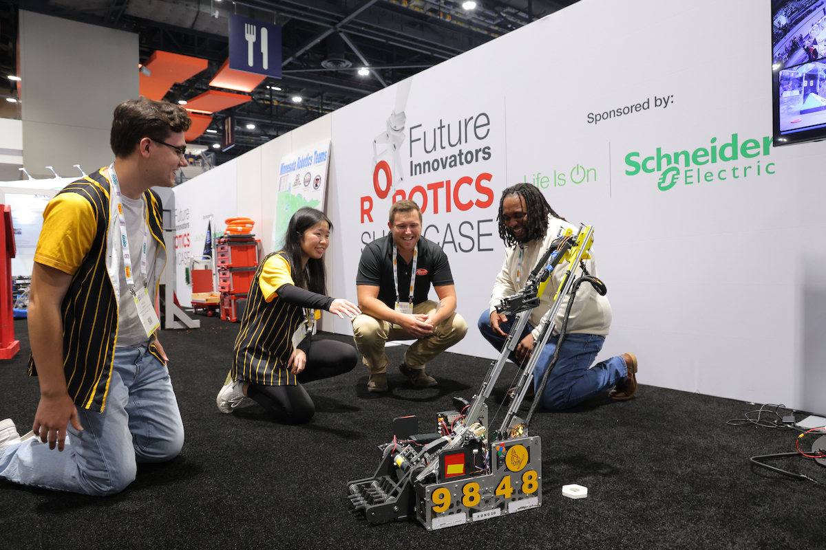 Team members demonstrate a robotics competition robot at the Future Innovators Robotics Showcase, sponsored by Schneider Electric.