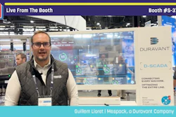 Man presenting at Pack Expo booth #S-3714 with Duravant D-SCADA industrial automation display
