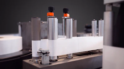 Collection of skincare and cosmetic bottles with orange caps displayed on white platform
